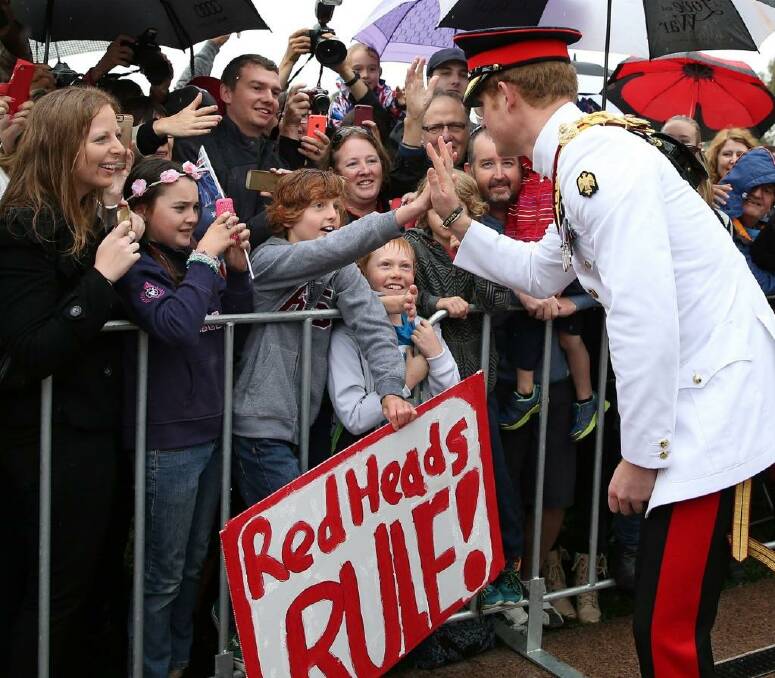 Prince Harry, one of the best known modern-day redheads shares a high five with Ethan Toscan, 12, from Bruce. Photo: Kym Smith