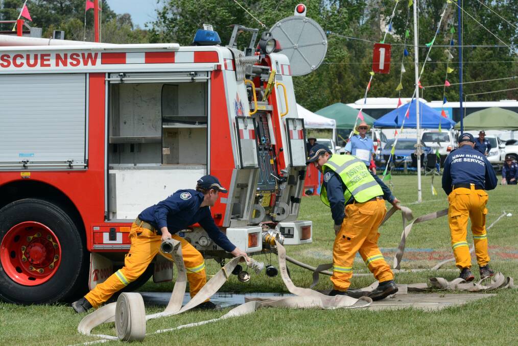 ACTION STATIONS: Members of the Kootingal Fire Brigade team taking part in the hose, hydrant and extinguisher event at Bathurst Showground yesterday. Photo: PHILL MURRAY	 1022414pfire3