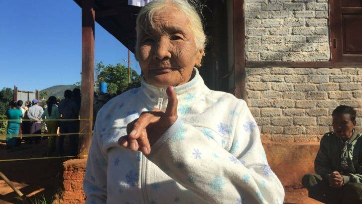 An elderly woman shows her inked finger. Photo: Anne Davies