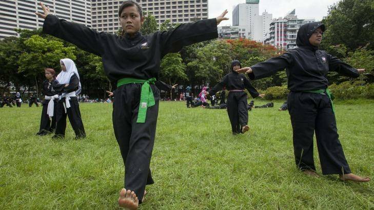 Indonesians working abroad as maids encounter exploitation and abuse. Here they learn self-defence on their day off in Victoria Park, Hong Kong. Photo: Alex Hofford
