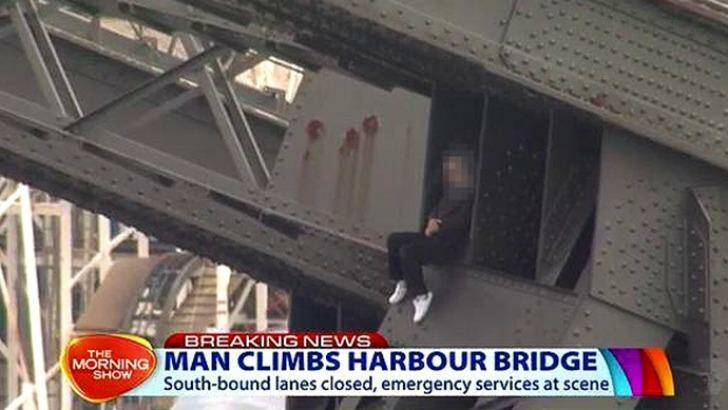 A man sits on the Sydney Harbour Bridge after climbing the structure on Friday. Photo: Supplied/Channel 7