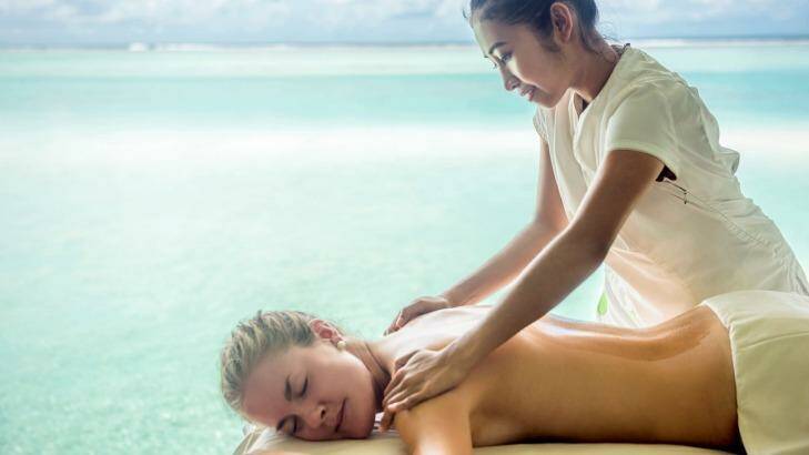 A massage therapist treats a guest in an over-water room at PER AQUUM Niyama, Maldives.
