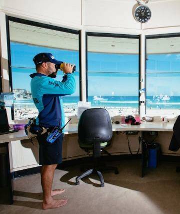 Daniel "Beardy" McLaughlin, a lifeguard at Bondi Beach, keeps a watchful eye on beachgoers. Directly above him is a camera which creates a live feed. Photo: Cole Bennetts (Fairfax Media via Getty Images)
