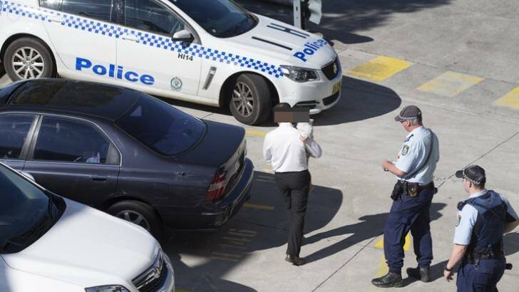 Police with the man who left his child in the car while he went for a job interview. Photo: Geoff Jones 