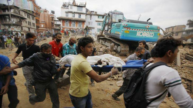 Volunteers carry the body of a victim on a stretcher, recovered from the debris of a building that collapsed after an earthquake  in Kathmandu, Nepal, Saturday, April 25, 2015. A strong magnitude-7.9 earthquake shook Nepal's capital and the densely populated Kathmandu Valley before noon Saturday, causing extensive damage with toppled walls and collapsed buildings, officials said. (AP Photo/ Niranjan Shrestha) Photo: Niranjan Shrestha