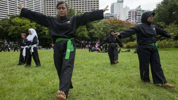 Indonesians working abroad as maids encounter exploitation and abuse. Here they learn self-defence on their day off in Victoria Park, Hong Kong.  Photo: Alex Hofford