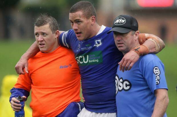 Blessing in disguise: Kane Evans helped off the field after injuring himself in a Newtown Jets game.  Photo: Dallas Kilponen