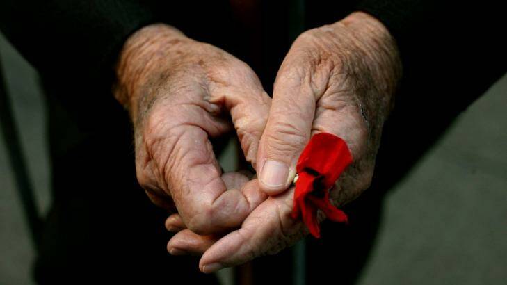 A WWII veteran holds a poppy at the Cenotaph on Anzac Day, 2009. Photo: Steven Siewert