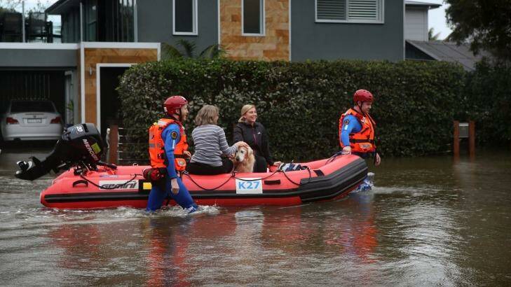 Residents evacuate their homes  as rising waters inundate Narrabeen Street, Narrabeen.   Photo: James Alcock