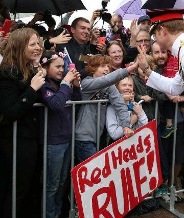 Prince Harry, one of the best known modern-day redheads shares a high five with Ethan Toscan, 12, from Bruce. Photo: Kym Smith