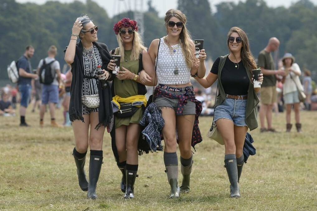 Girls walk across the park with drinks, with left to right, Heather Shillito, Amy Parren, Charlotte Burden and Emma Spafford, enjoying day two of the V Festival, at Weston Park, England, Sunday Aug. 23, 2015.  The annual music festival attracts some top acts. (Joe Giddens / PA via AP) UNITED KINGDOM OUT - NO SALES - NO ARCHIVES Photo: PA