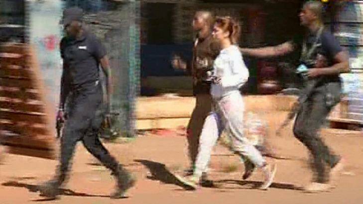 A woman is led away by security from the Radisson Blu Hotel in Mali. Photo: Mali TV ORTM