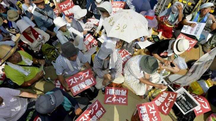 Protesters stage a rally near the gate of the Sendai Nuclear Power Station. Photo: AP/Kyodo