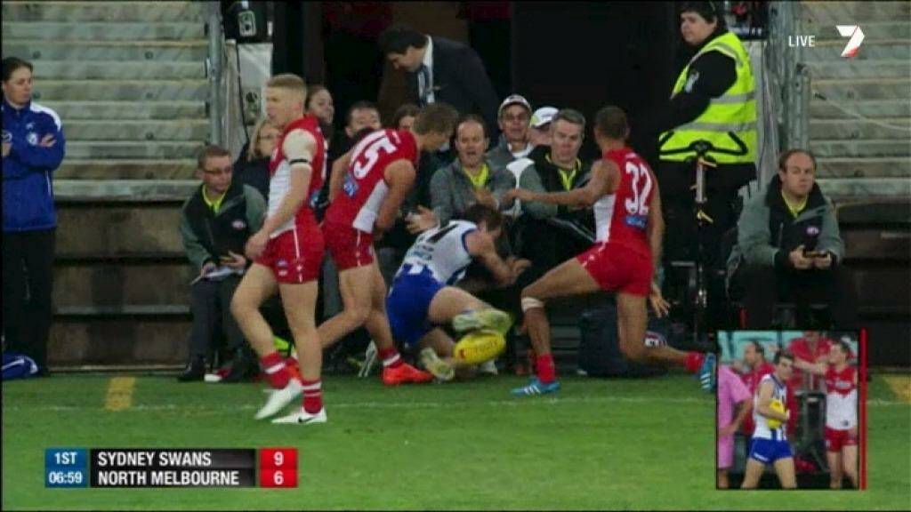 Down and out: Luke McDonald is slung into officials seated between the interchange benches by Kieren Jack.  Photo: Channel Seven