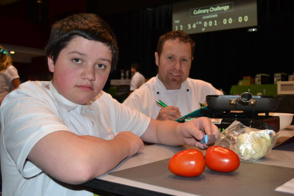 CULINARY CHALLENGE: Judge Paul Coopes from Stumpy s on Stewart with Carenne School student Jacob Bettles, 14, who was about to cook during yesterday s Western NSW Culinary Challenge at the Bathurst Memorial Entertainment Centre. Photo: BRIAN WOOD 	102814challenge