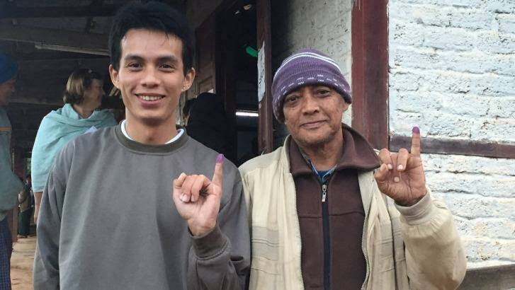 Men from different generations display their inked fingers after voting. Photo: Anne Davies