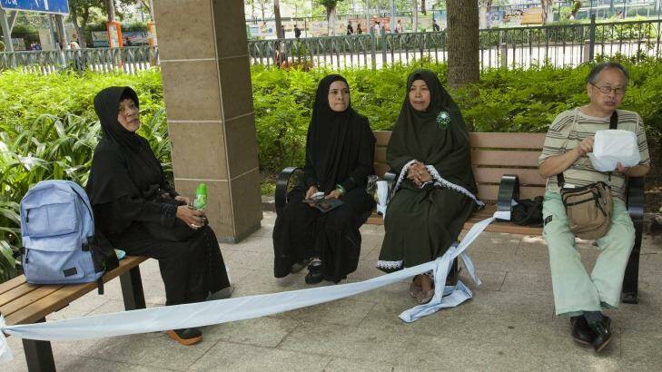 Religious Indonesian domestic helpers improvise a women-only seating area in Hong Kong's Victoria Park on their day off. Photo: Alex Hofford
