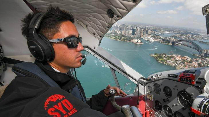 Pilot Daniel Johnson flies over Sydney Harbour.  Photo: Peter Rae 
