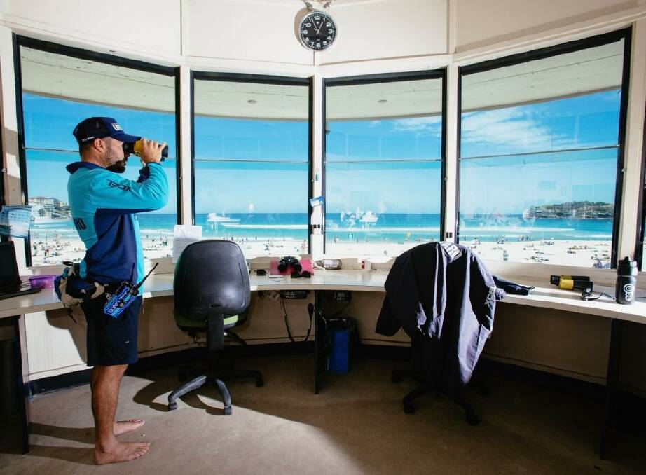Daniel "Beardy" McLaughlin, a lifeguard at Bondi Beach, keeps a watchful eye on beachgoers. Directly above him is a camera which creates a live feed. Photo: Cole Bennetts (Fairfax Media via Getty Images)