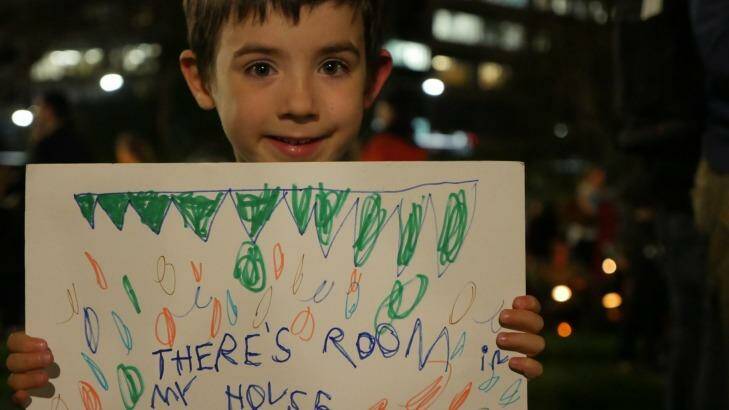 "There's room in my house" says a sign held by Xavier, who is just two years older than Aylan Kurdi, at the Light the Dark rally in Sydney.  Photo: Supplied