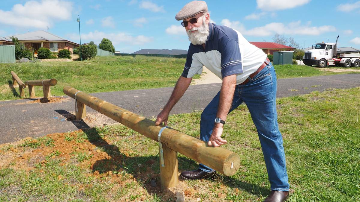 BATHURST: Llanarth resident George Ballard with the log barriers which have been installed to stop motorists from using a short cut which runs behind the Bathurst Baptist Church. Photo: ZENIO LAPKA 033114zroadblock1