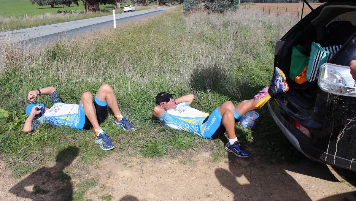 STILL SMILING: Shane Taylor and Tim Blair take a rest on the side of the road in country NSW. Despite his stress fracture, Tim Blair still mananges a smile. Picture: Jonathan Mallinson.