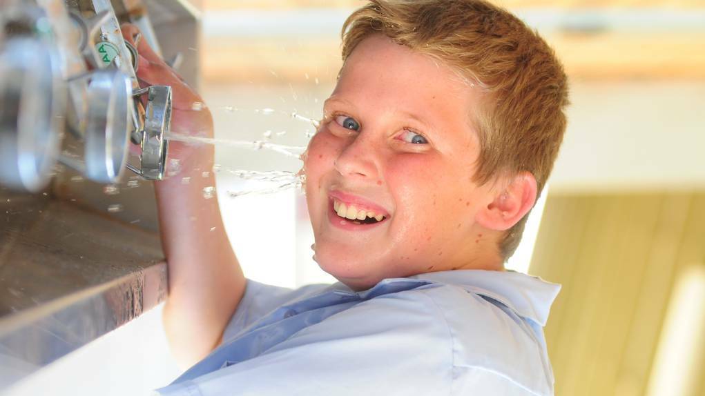 DUBBO: St John s College student Harry O'Mally cools off in yesterday s heat. Photo LOUISE DONGES