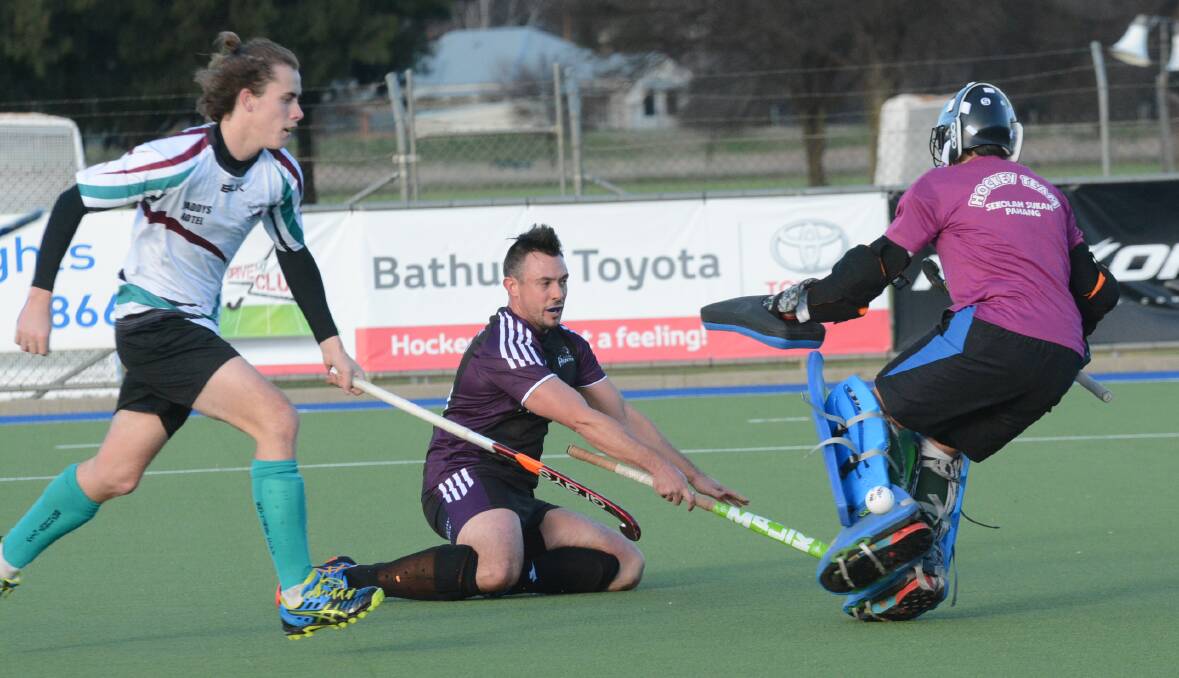 PRESSURE: The ball slides off the pads of Bathurst City goalkeeper Tom Scott as he tries to shut down a Lithgow Panthers rival in Saturday’s Premier League Hockey match. Photo: PHILL MURRAY 	062516ppanthers3