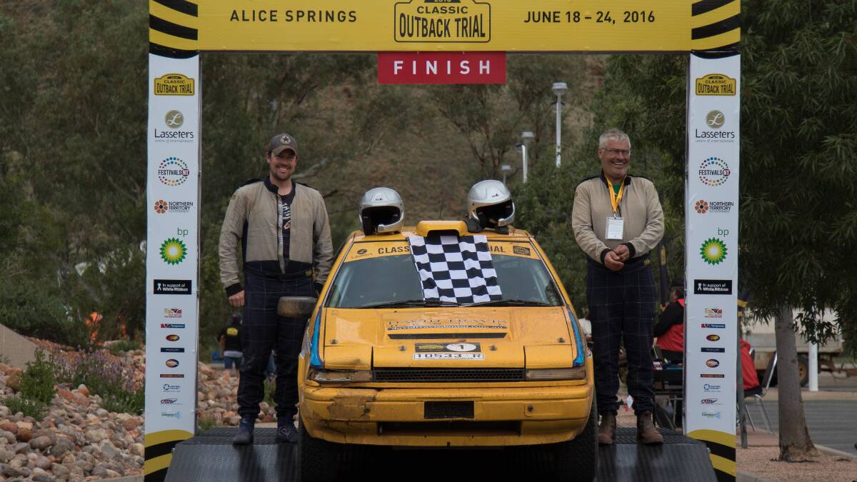 YOU BEAUTY: Bathurst’s Andrew (left) and David Travis offer a smile on the podium after winning their third Classic Outback Trial crown. They raced a 1984 Nissan Gazelle in the Alice Springs based event. Photo: Craig O’Brien, Classic Outback Trial 	062516travis