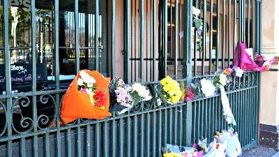 HEARTFELT: Members of the community reeling from the loss of two people last week have shown their big hearts by leaving flowers tucked into the gates of Elie’s Cafe. Photo: RACHEL FERRETT 071915rfsnap1 