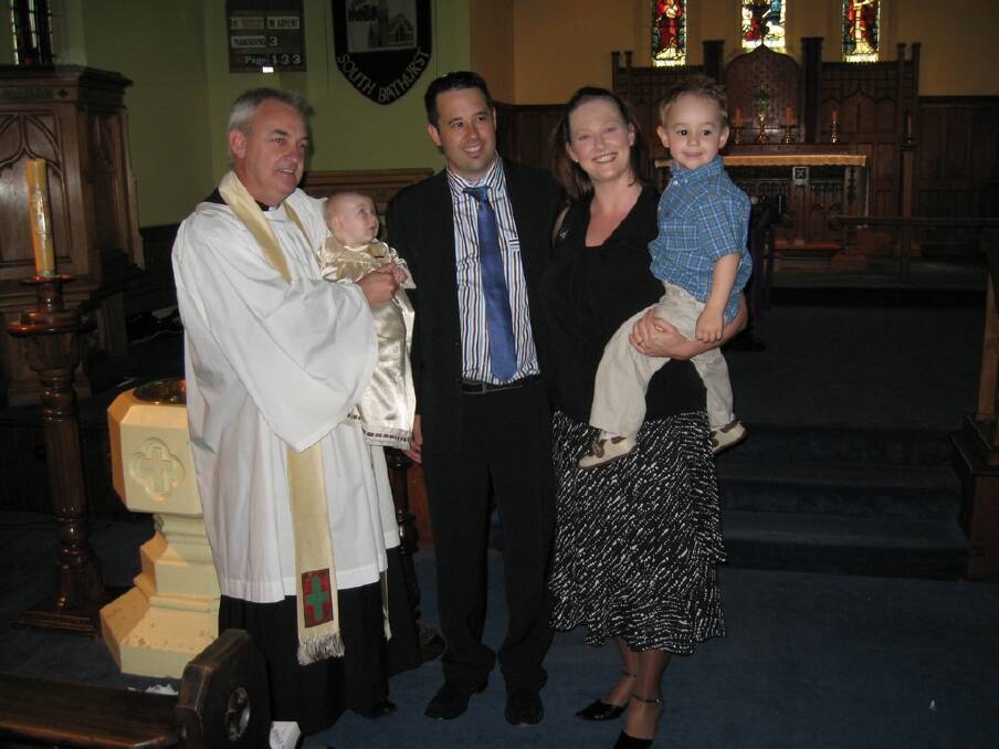 Rev. Hodson holding Jenson Hornery with James, Leanne and Aston Hornery during the baptism of Jenson Hornery in 2010. . Submitted by Leanne Hornery.