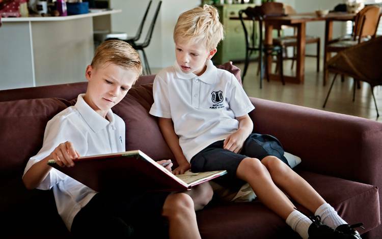 Oliver Gumpert was reading a story to Henri Gumpert just before starting his first day of school at Bathurst Public School. He was also sharing helpful advice to Henri on what to do at his new school.