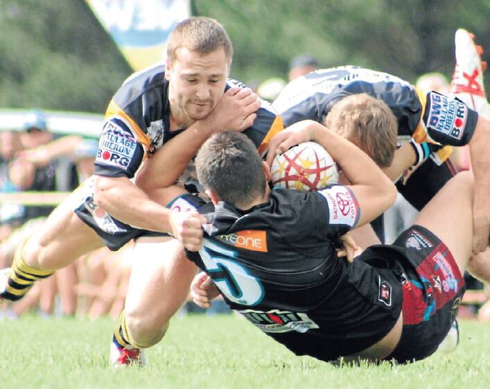GROUND DOWN: Oberon’s Reece Finlay and Joel Christie-Johnston take down Panthers winger Josh Small. Photo: KIM BROWN