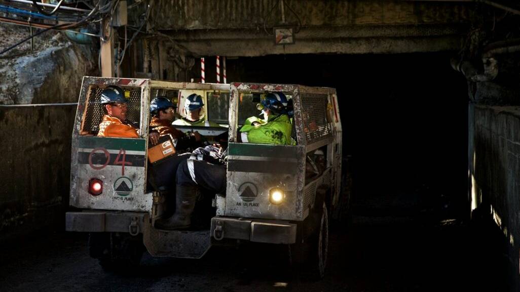 Springvale mine workers share a joke as their personnel train starts the long descent underground. Photo: Wolter Peeters