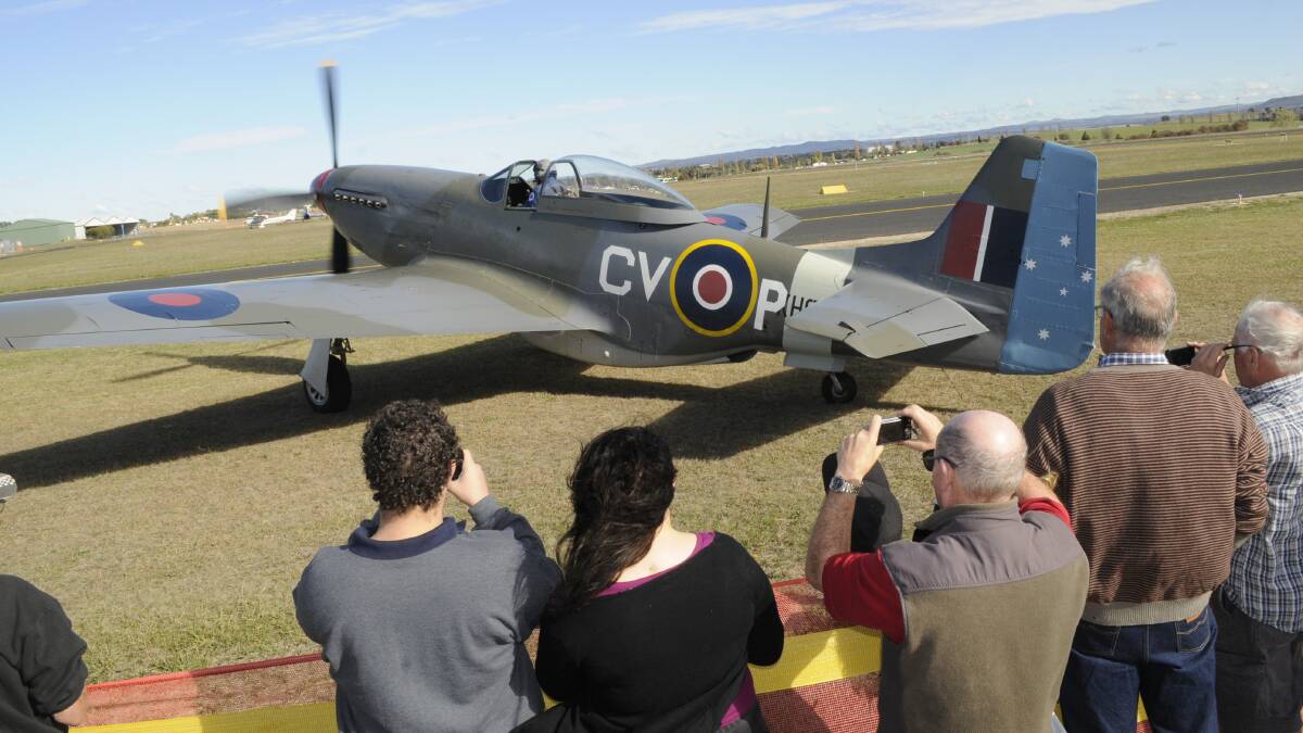 PLANE SPOTTERS: All cameras were focused on this World War II P 51 Mustang, as it waited to take to the air for yesterday's Soar Ride and Shine show at Bathurst Airport. Photo: CHRIS SEABROOK 051516cairshw2