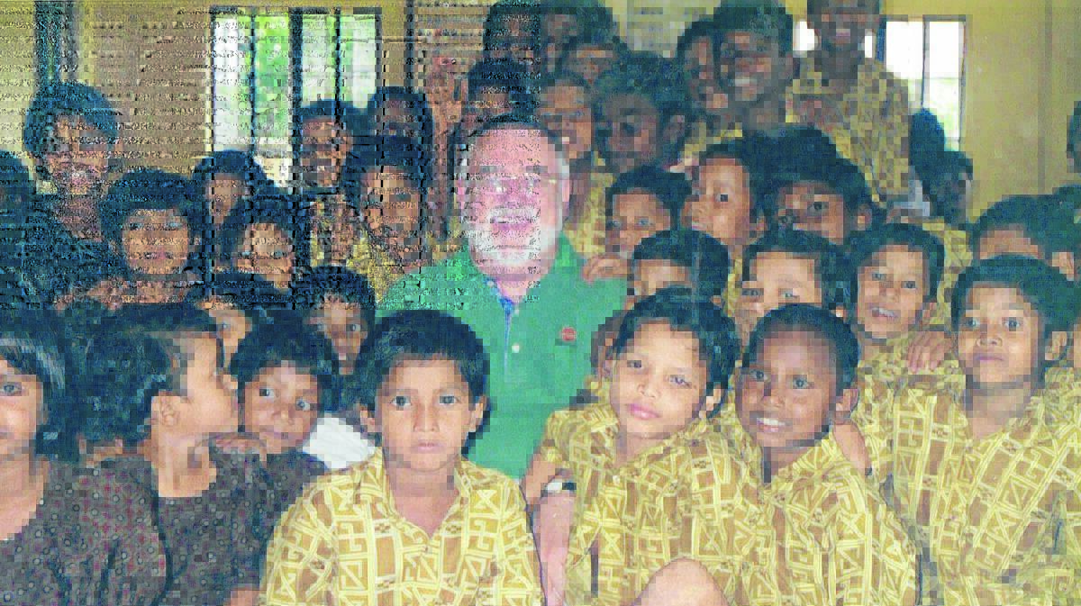 DESERVED HONOUR: Pastor Bob Smith, pictured with children at a Bangladesh school, is set to receive a special award for his services. 	012715pastorbob