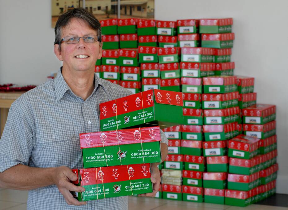MERRY CHRISTMAS: Pastor Steve Blackwell of the Christian Life Centre with some of the Christmas parcels that will soon be sent out to children across Australasia Photo: ZENIO LAPKA	 103014zblackwell
