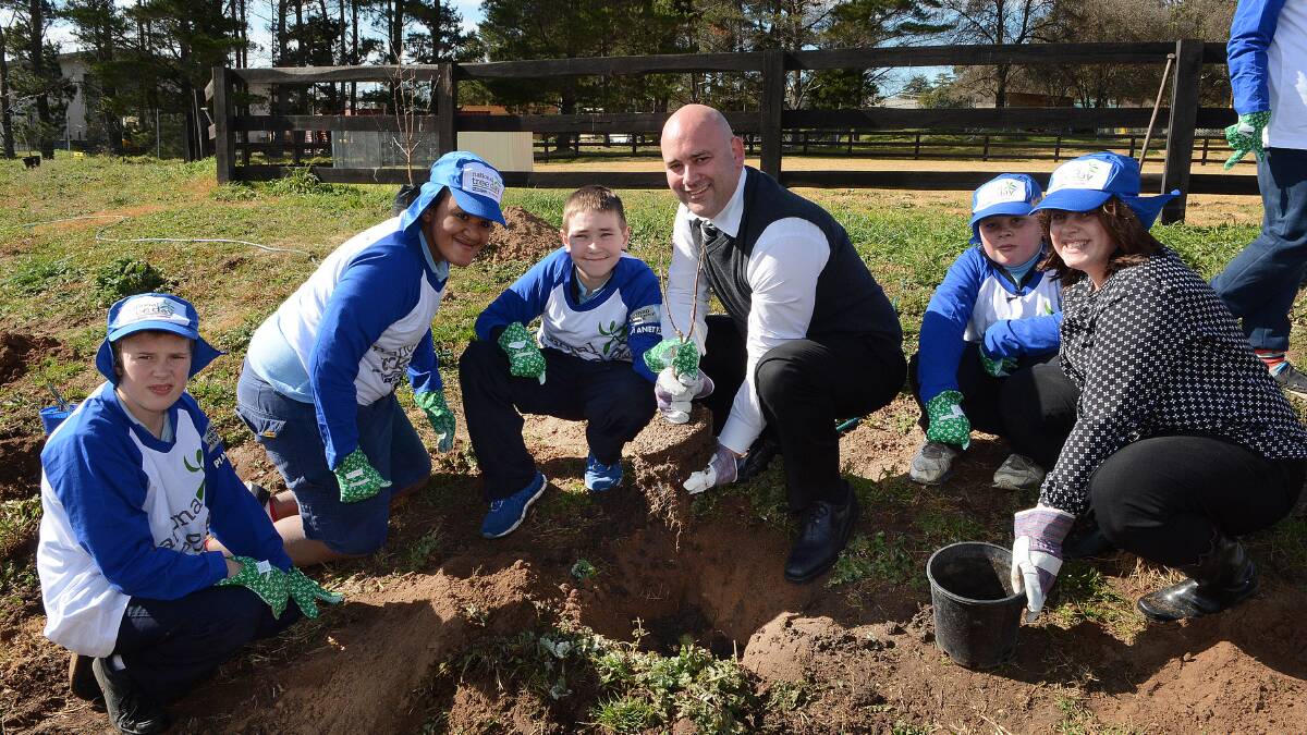 TREE DAY: Bathurst Toyota’s Shane Gilchrist and Lenore Woolley with Carenne School students James, Eathan, Jake and Aiden. Photo: PHILL MURRAY	 072514pcarenne