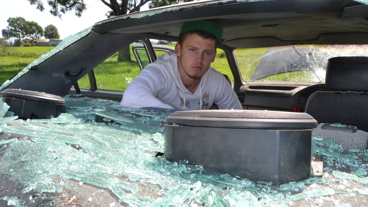 DEVASTATED: Nigel Simmons was devastated to find his white EA Falcon badly vandalised when he went to check on the car which was parked by the roadside on Hereford Street with numerous other vehicles up for sale. 	041714vandals