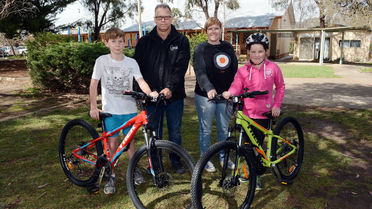 ON THEIR BIKES: Proud Pedal Push winners Riley Ledingham, 10, and Natalie Halpin, nine, with sponsors Stephen Brydon from Wheeler Cycles and Tammy Taylor of Al Dente at Eglinton Public School yesterday. Photo: PHILL MURRAY  	091914pbikes1