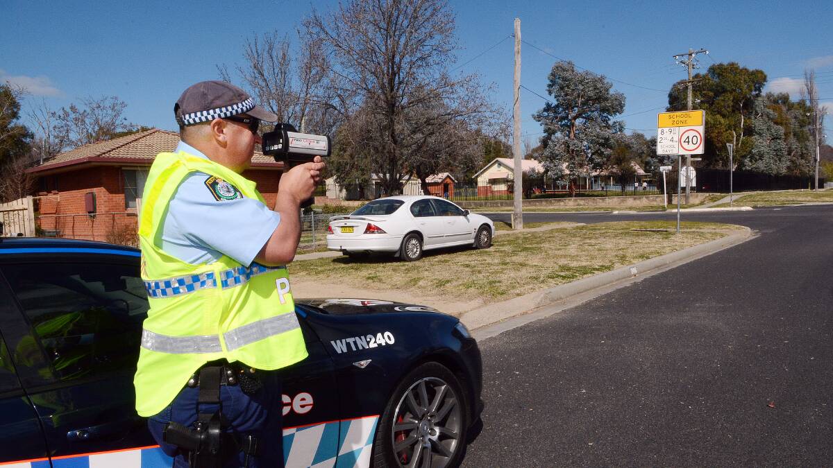 OPERATION COMPLIANCE 3: Senior Constable Brett Mooney monitoring the traffic in a local school zone yesterday. Photo: PHILL MURRAY 	081314pcompli
