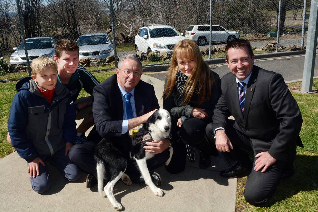 HERE TO HELP: Matthew Forster, 11, inmate Chris, attorney general Brad Hazzard, Margot Forster and Member for Bathurst Paul Toole with Jakie the dog. Margot, a 34-year serving member of the Royal Australian Air Force, and her son Matthew received Jakie through the Dogs for Diggers program. Photo: PHILL MURRAY	 090314pdogs23	