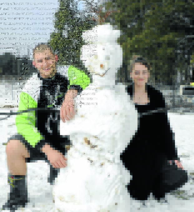 SNOW SCULPTURE: Julian Gaal and Amanda Di Fazio with the fabulous snowman they built at Yetholme yesterday. Photo: CHRIS SEABROOK