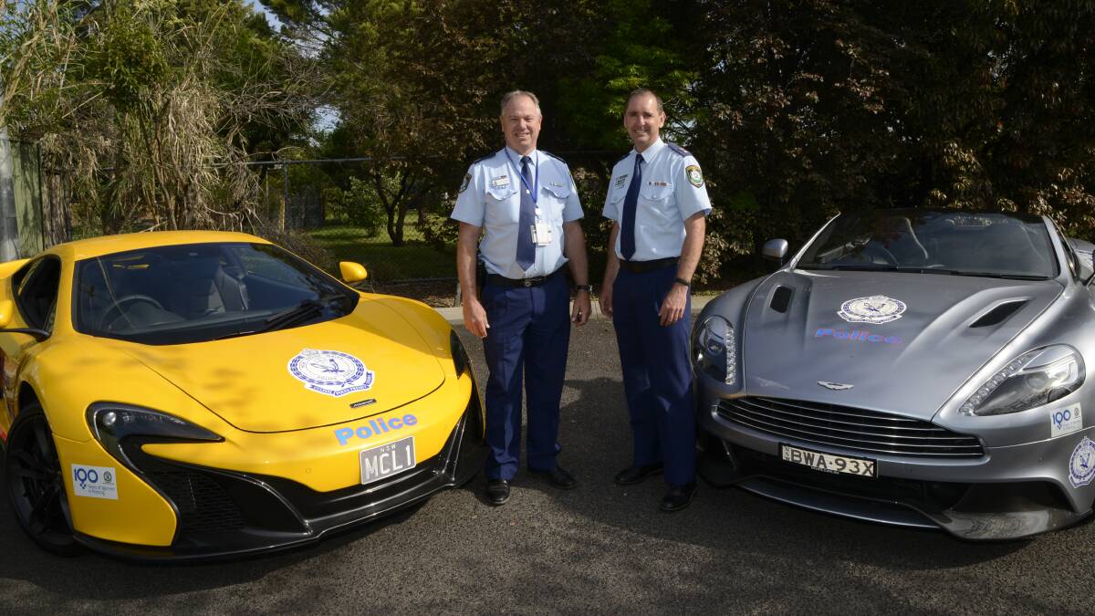 HOT WHEELS: Assistant Commissioner Geoff McKechnie and Chifley local area commander Superintendent Michael Robinson with the McLaren and Aston Martin in Bathurst yesterday. Photo: PHILL MURRAY	 100715pcars1