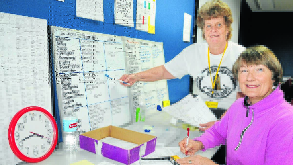 ORGANISED: Eisteddfod volunteers Pam Andersen and Larraine Griffin at work in the nerve centre yesterday. Photo: CHRIS SEABROOK	 082714cvoluntrs
