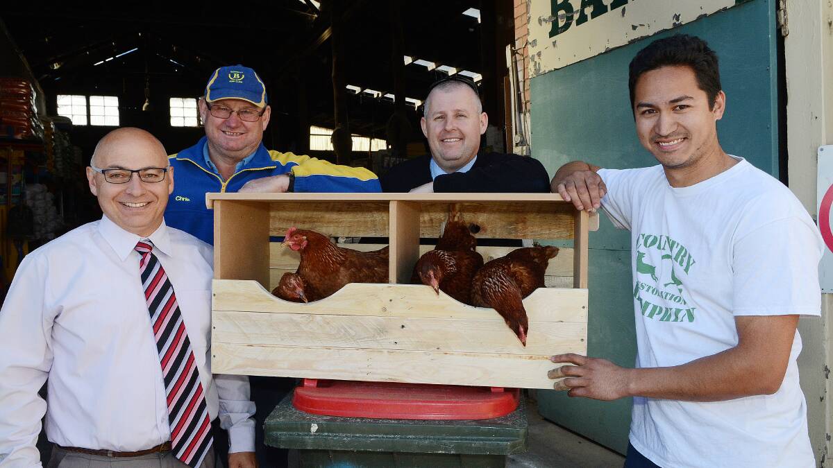 HOME TO ROOST: Bathurst South Public School principal Greg Cross, Bedwells’ Chris Frisby, Bathurst Real Estate’s Jay Cleary and the Country Bumpkin’s Tobbie Muldoon with some of the new nesting boxes. Photo: PHILL MURRAY	 082014pchooks1