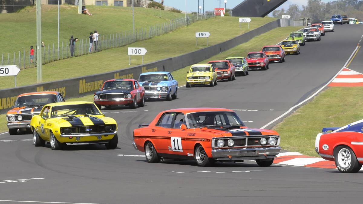 LOCAL PRIDE: Michael Anderson came second in the Group N Historic Touring Cars race yesterday morning in his Ford Falcon XY GTHO 3 (car 11). Photo: CHRIS SEABROOK 	042014cbmf3