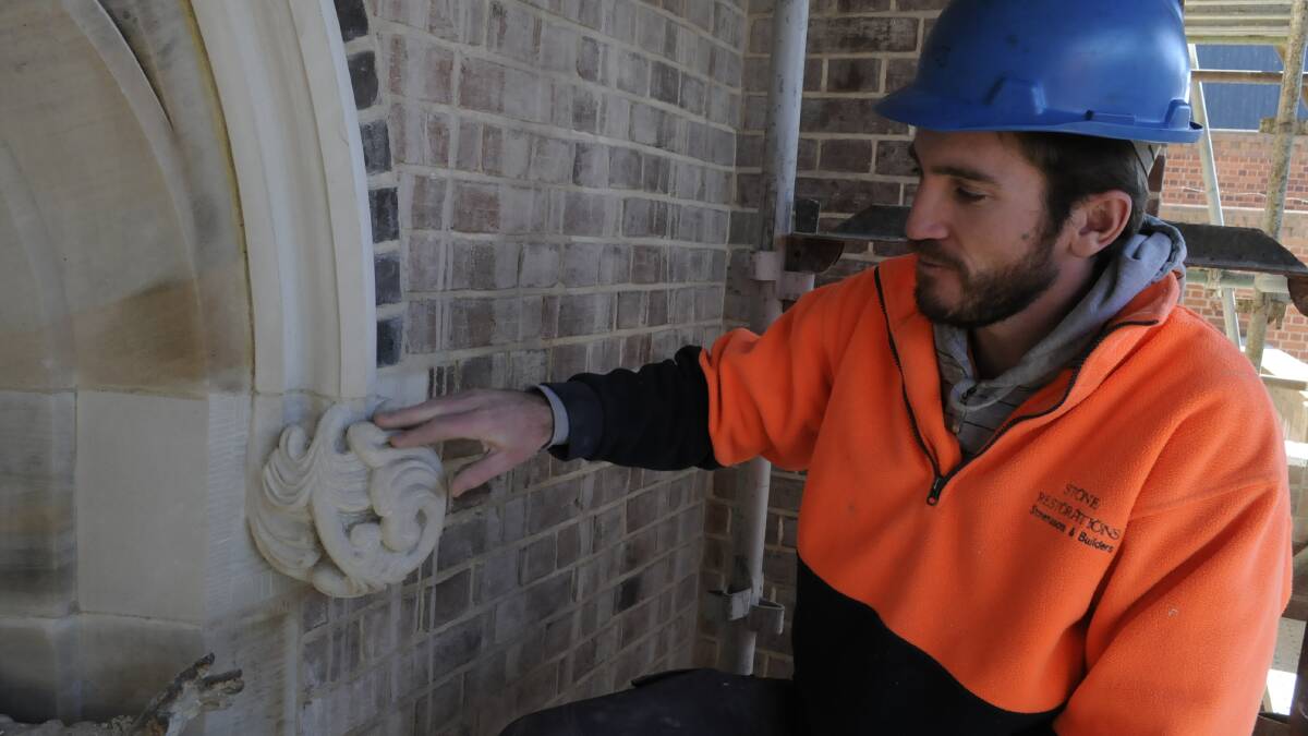 HANDY WORK: Stone Restorations' Josh Maloney (above) is the acting site supervisor at the Cathedral of St Michael and St John restoration project. He is working on the lower sandstone arches on the eastern side of the bell tower. 