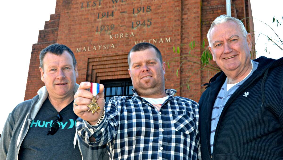 REUNITED: Bathurst resident Jeff Oliver, left, is pleased to have finally handed the 1914-15 Star medal belonging to Private Thomas Scougall to his great-grandson Simon Crowther, centre, and grandson Alan Young. Photo: RACHEL FERRETT 	052415rfmedal