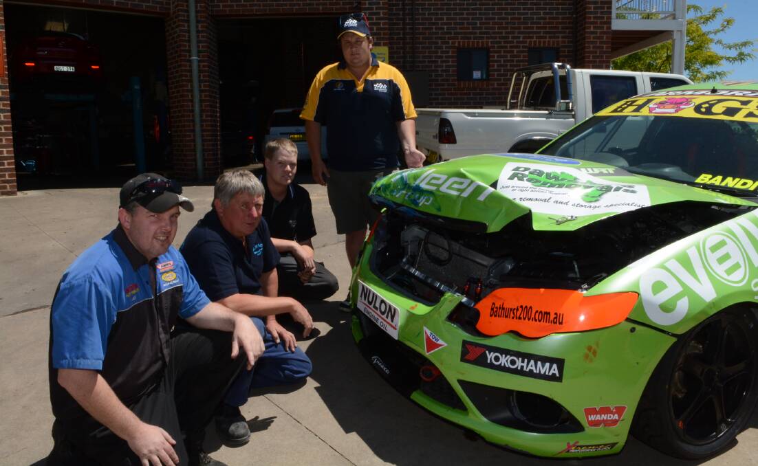 FIXING TIME: Joe Chapman, Ken Wright, Ben Staines and Terry Nightingale stand by the Ford FG ute set for repairs in the lead up to the final round of the V8 Utes championship in December at Sydney. Photo: PHILL MURRAY 	102914pterry3